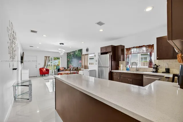 a large kitchen with counter top space cabinets and stainless steel appliances