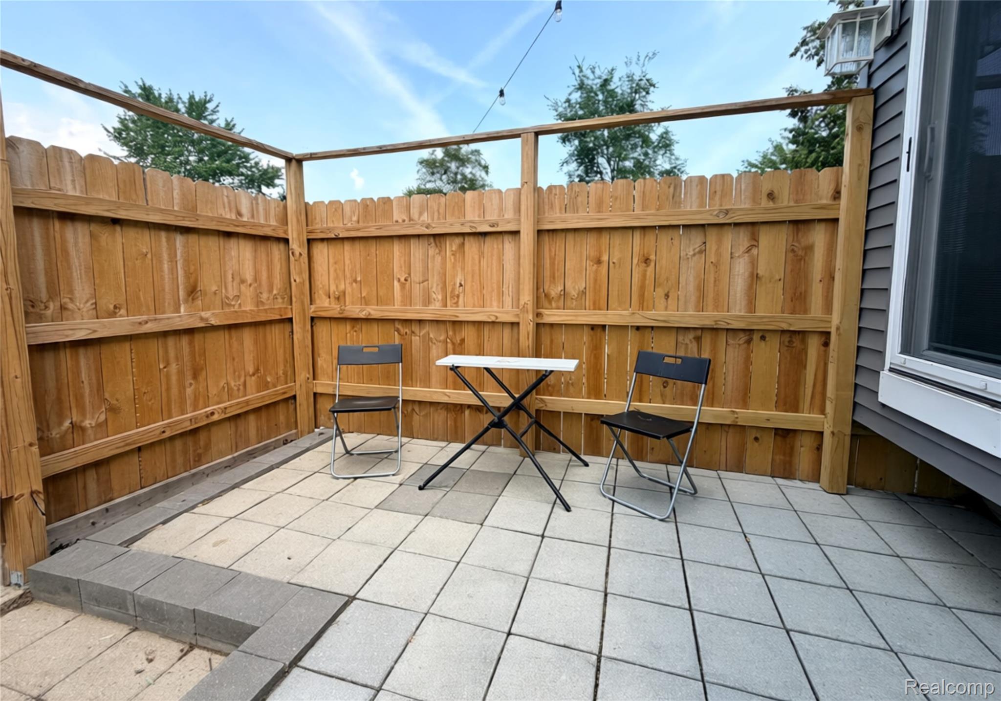 3840 East Dunbar Road Monroe, MI 48161 - Photo 6 of 38 Outdoor patio featuring paver flooring, wood privacy fencing, and a corner pergola frame