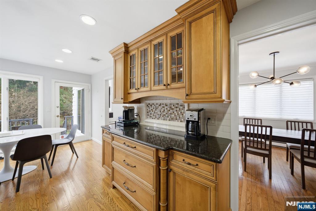 126 Sussex Road Tenafly, NJ 07670 - Photo 12 of 50 a kitchen with granite countertop a stove a sink a dining table and chairs