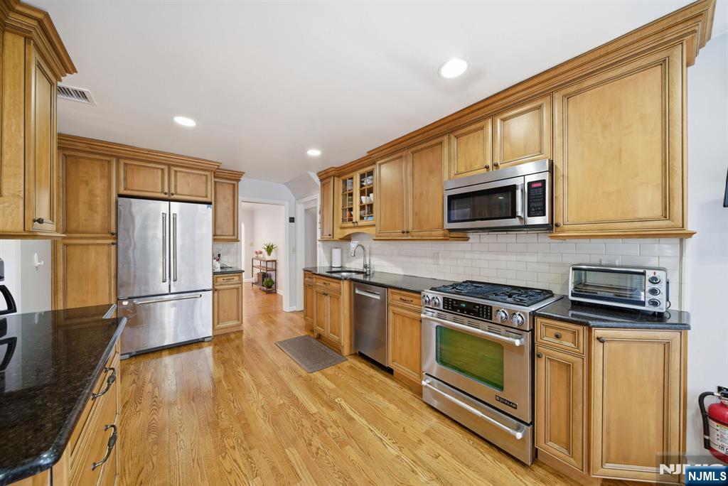 126 Sussex Road Tenafly, NJ 07670 - Photo 14 of 50 a kitchen with stainless steel appliances a stove a refrigerator and a microwave
