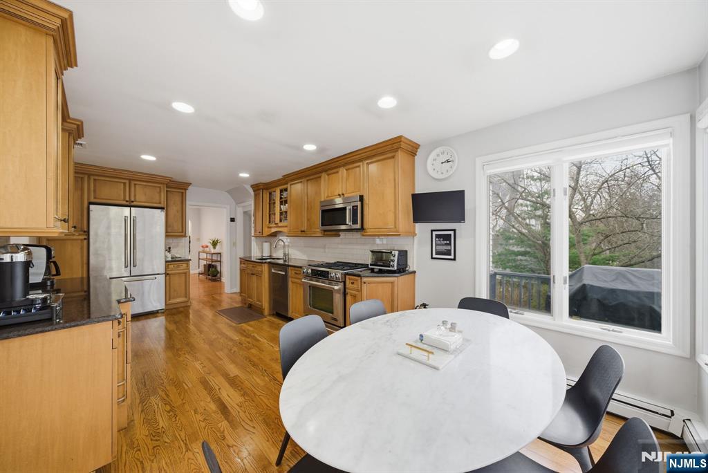 126 Sussex Road Tenafly, NJ 07670 - Photo 16 of 50 a large kitchen with a table chairs refrigerator and microwave
