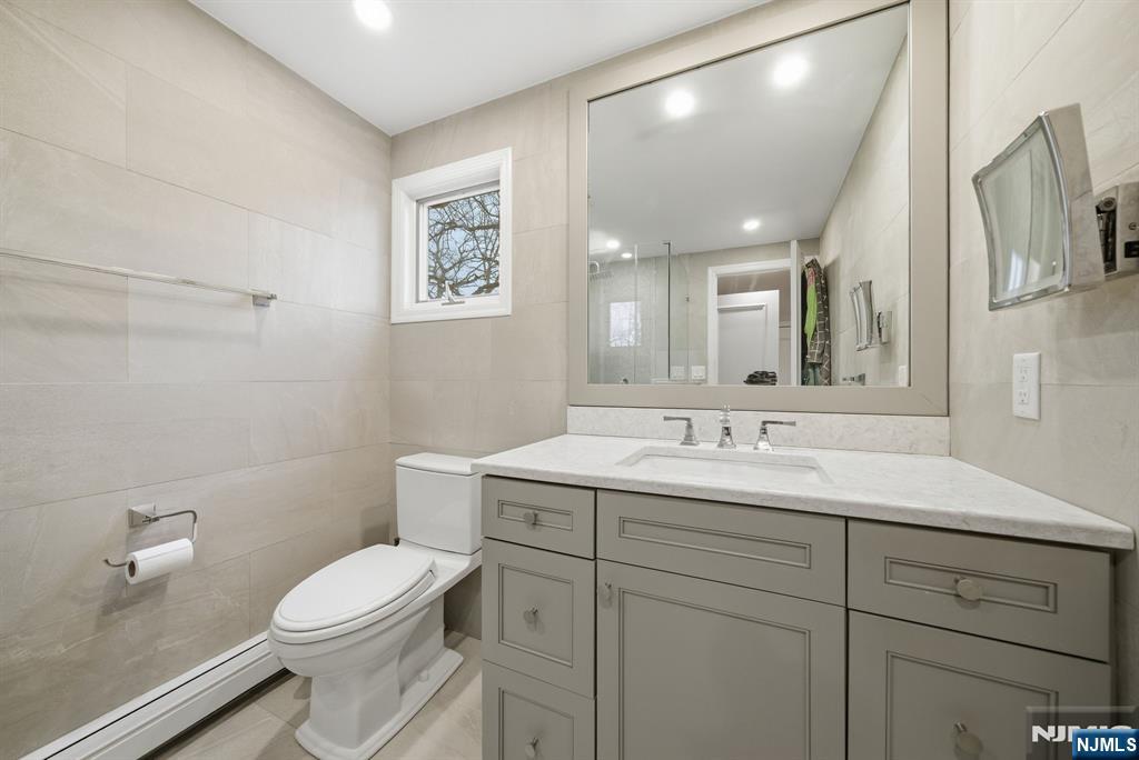 126 Sussex Road Tenafly, NJ 07670 - Photo 39 of 50 a bathroom with a toilet a sink a mirror and vanity