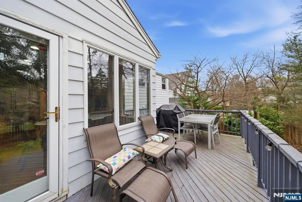 126 Sussex Road Tenafly, NJ 07670 - Photo 43 of 50 a view of a patio with a dining table and chairs with wooden floor