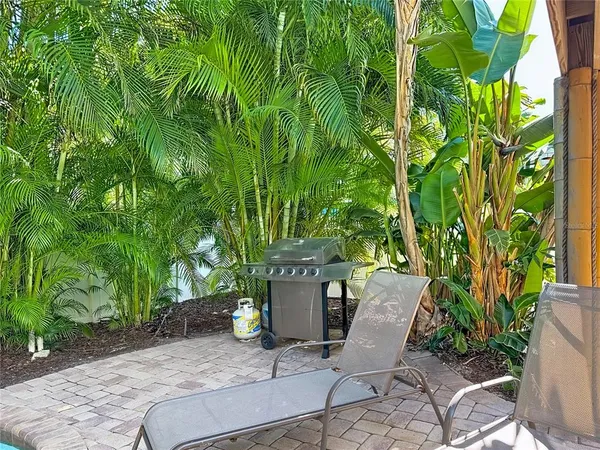 a view of a patio with table and chairs potted plants with wooden floor and fence