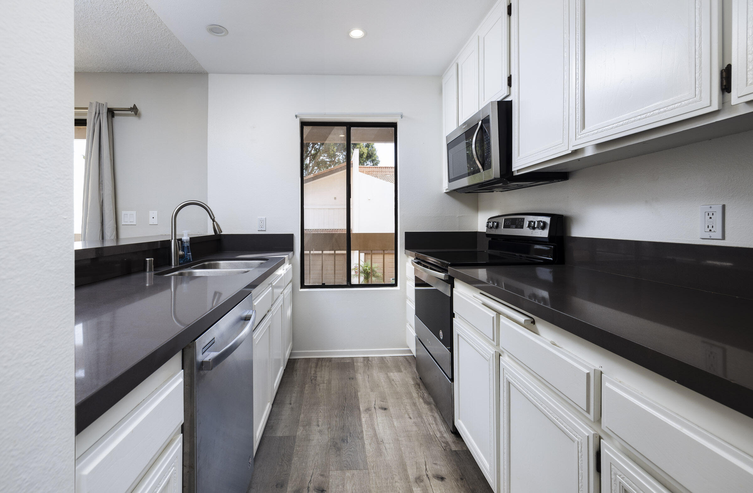 653 Verde Mar Drive, Unit E Santa Barbara, CA 93103 - Photo 11 of 23 a kitchen with granite countertop a sink stainless steel appliances and cabinets