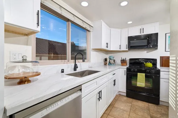 a kitchen with stainless steel appliances granite countertop a sink and a stove