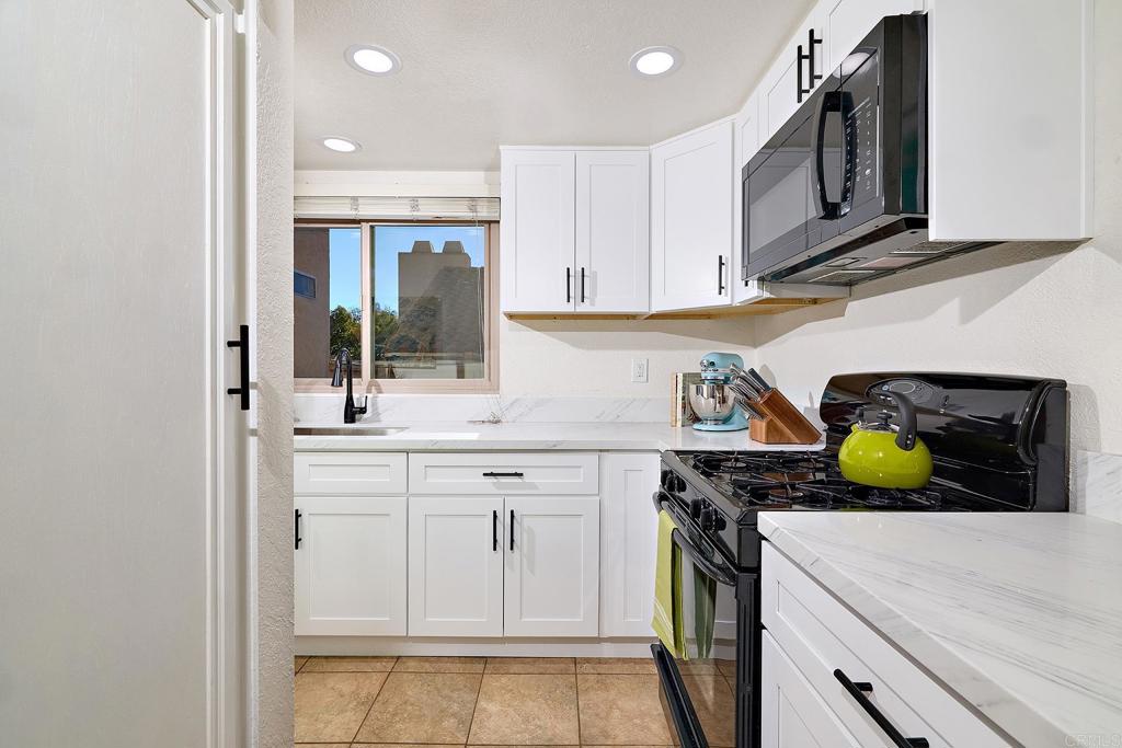 1055 Ficus Lane San Marcos, CA 92069 - Photo 6 of 16 a kitchen with stainless steel appliances granite countertop white cabinets and a stove
