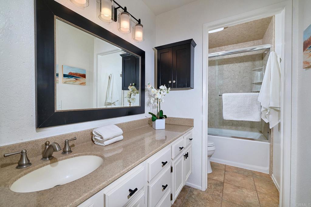 1055 Ficus Lane San Marcos, CA 92069 - Photo 10 of 16 a bathroom with a granite countertop sink and a mirror