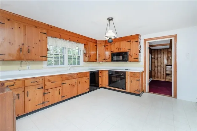 a kitchen with stainless steel appliances granite countertop a stove a sink dishwasher a refrigerator and a wooden cabinets