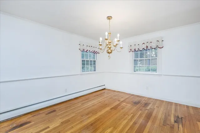 a view of a room with wooden floor and chandelier
