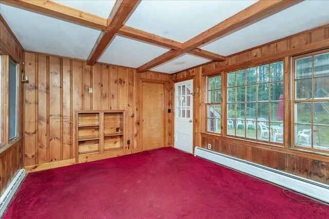 a view of empty room with wooden floor and windows