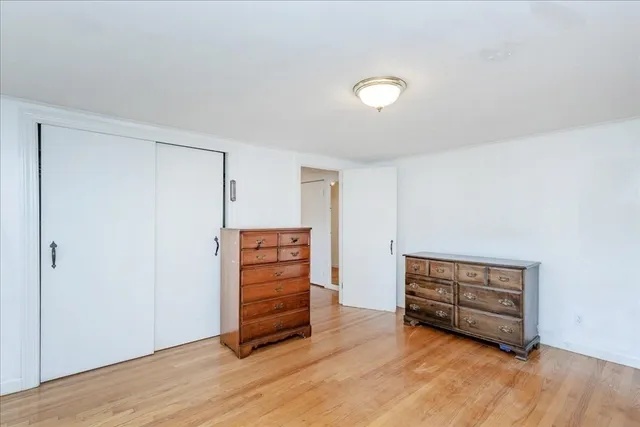 an empty room with wooden floor and closet