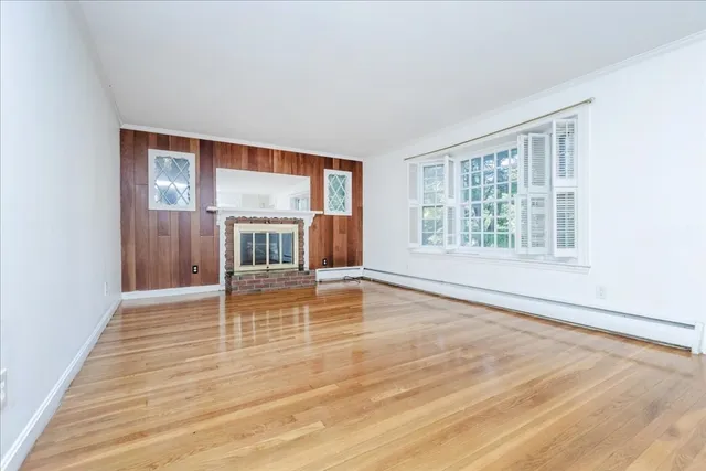 an empty room with wooden floor and window