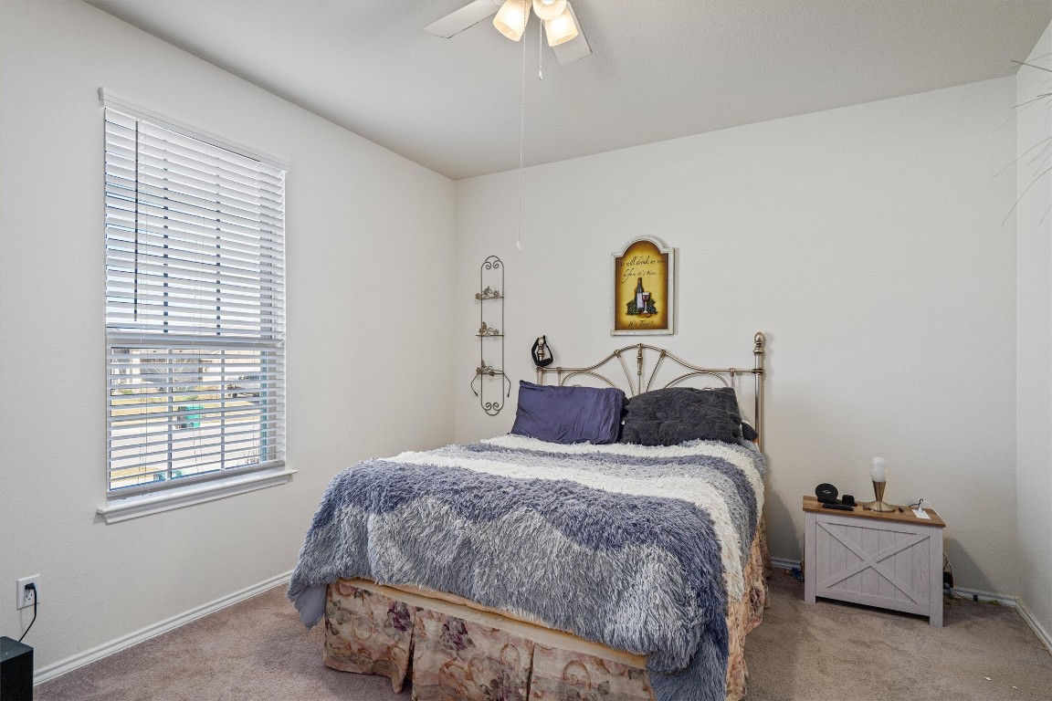 160 Gunther Way Taylor, TX 76574 - Photo 14 of 24 a bedroom with a bed and a chandelier