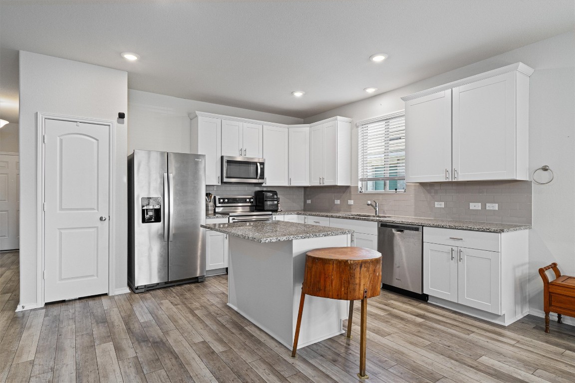 160 Gunther Way Taylor, TX 76574 - Photo 5 of 24 a kitchen with stainless steel appliances granite countertop a refrigerator sink and cabinets