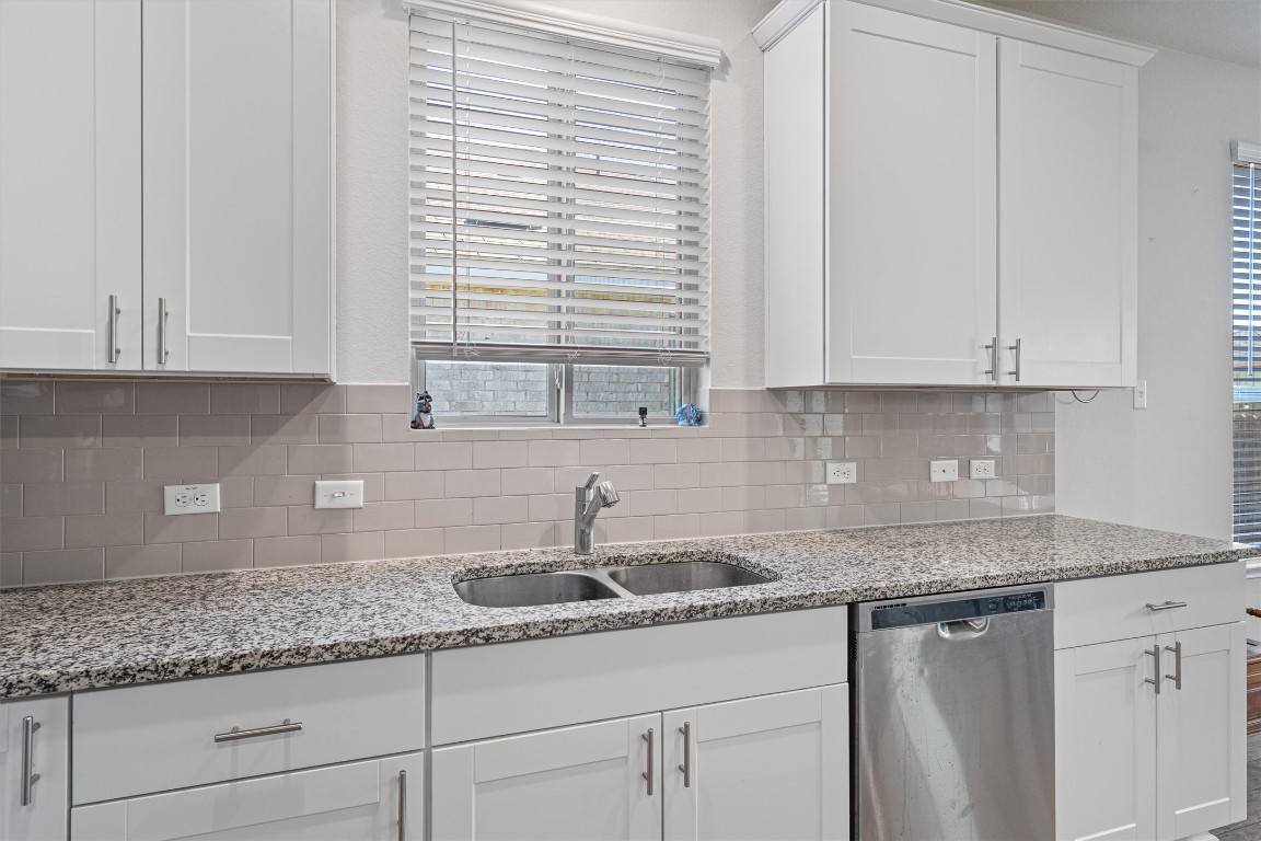 160 Gunther Way Taylor, TX 76574 - Photo 6 of 24 a kitchen with granite countertop white cabinets and a sink