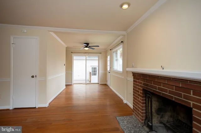 a view of a hallway with wooden floor and a window