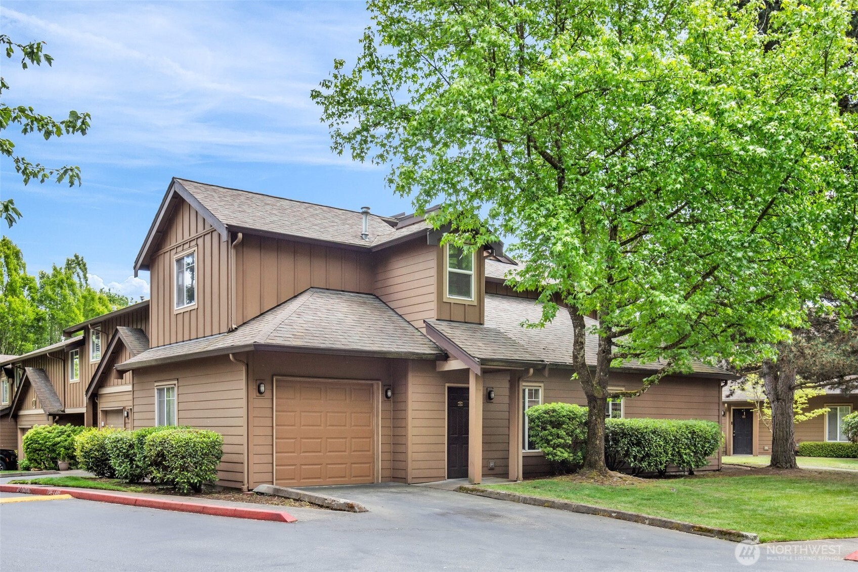 18930 Bothell Everett Highway, Unit J106 Bothell, WA 98012 - Photo 1 of 1 a front view of a house with a garden