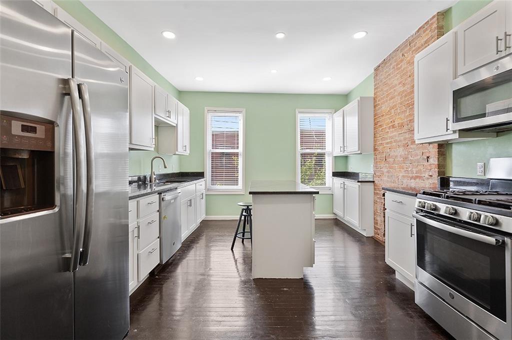 5206 Butler Street Pittsburgh, PA 15201 - Photo 5 of 24 a kitchen with stainless steel appliances a refrigerator a stove a sink and white cabinets