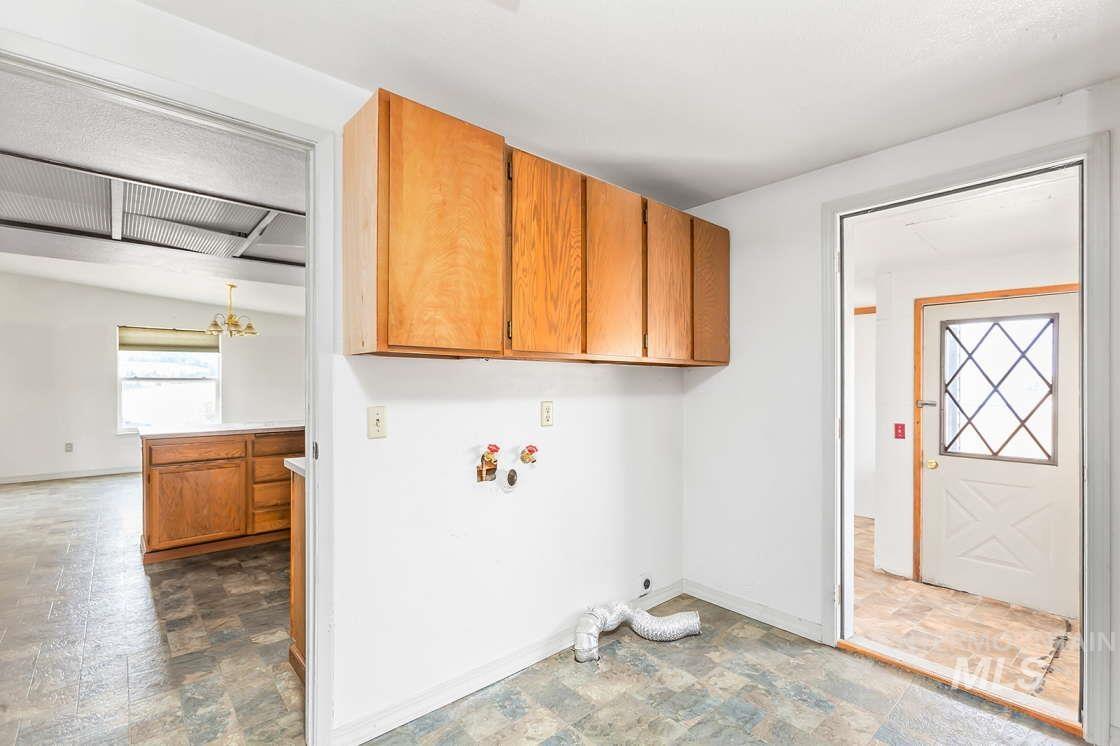 255 3 Bear Creek Road Kendrick, ID 83537 - Photo 19 of 44 Laundry area featuring stone finish flooring, a chandelier, cabinet space, washer hookup, and electric dryer hookup