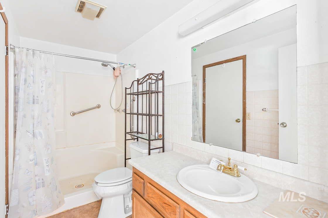 255 3 Bear Creek Road Kendrick, ID 83537 - Photo 21 of 44 Bathroom featuring vanity, a shower with shower curtain, and tile walls