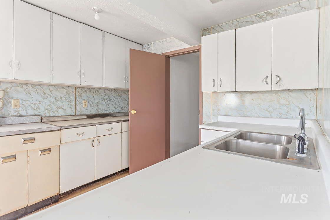 255 3 Bear Creek Road Kendrick, ID 83537 - Photo 35 of 44 Kitchen featuring decorative backsplash, light countertops, and white cabinets
