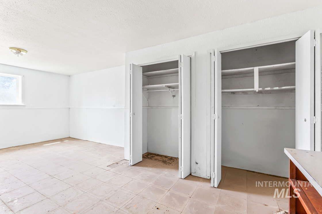 255 3 Bear Creek Road Kendrick, ID 83537 - Photo 43 of 44 Unfurnished bedroom featuring two closets and a textured ceiling
