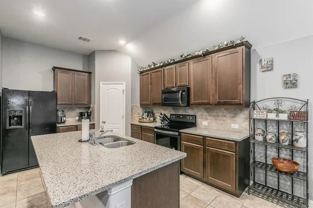 a kitchen with stainless steel appliances granite countertop a sink microwave and stove