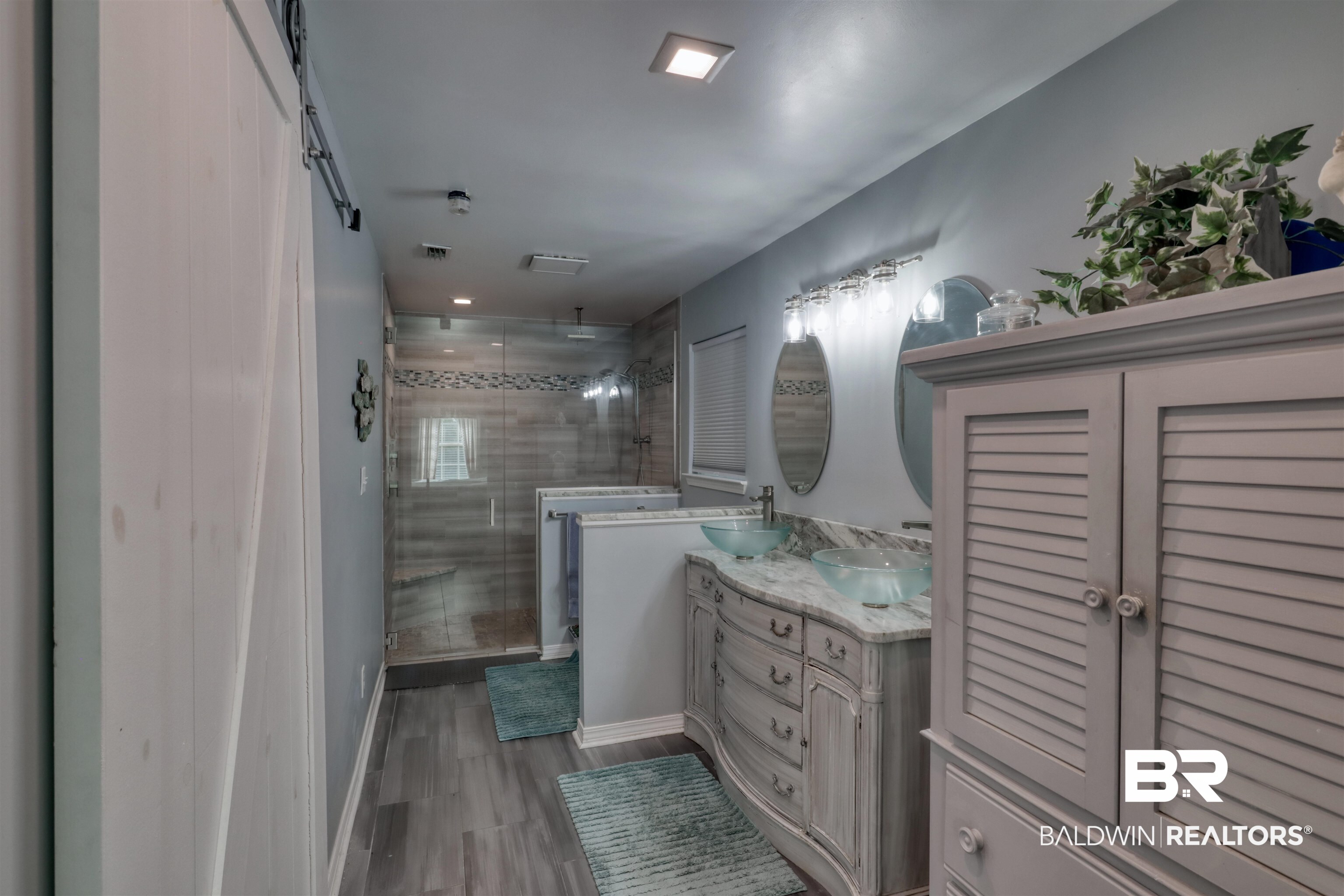 12893 Hunters Chase Foley, AL 36535 - Photo 26 of 42 Bathroom with a stall shower, a sink, wood finished floors, visible vents, and double vanity