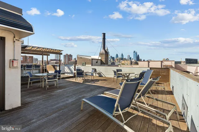 a balcony with wooden floor table and chairs