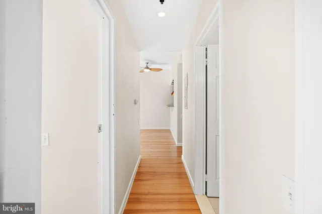 a view of a hallway with wooden floor