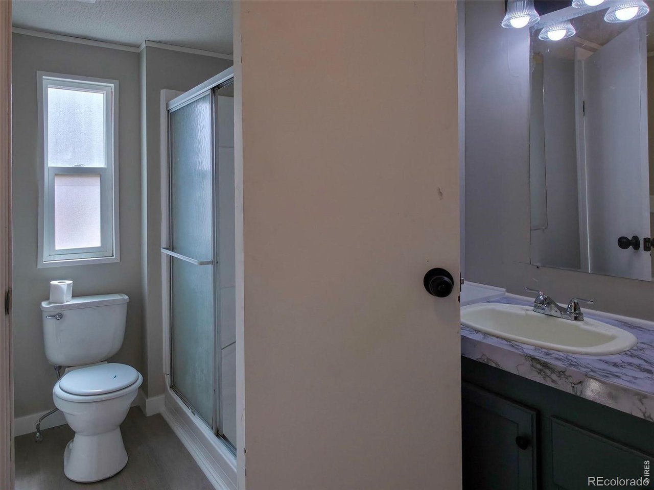 1401 9th Street, Unit 80 Fort Lupton, CO 80621 - Photo 11 of 21 a bathroom with a toilet sink and mirror