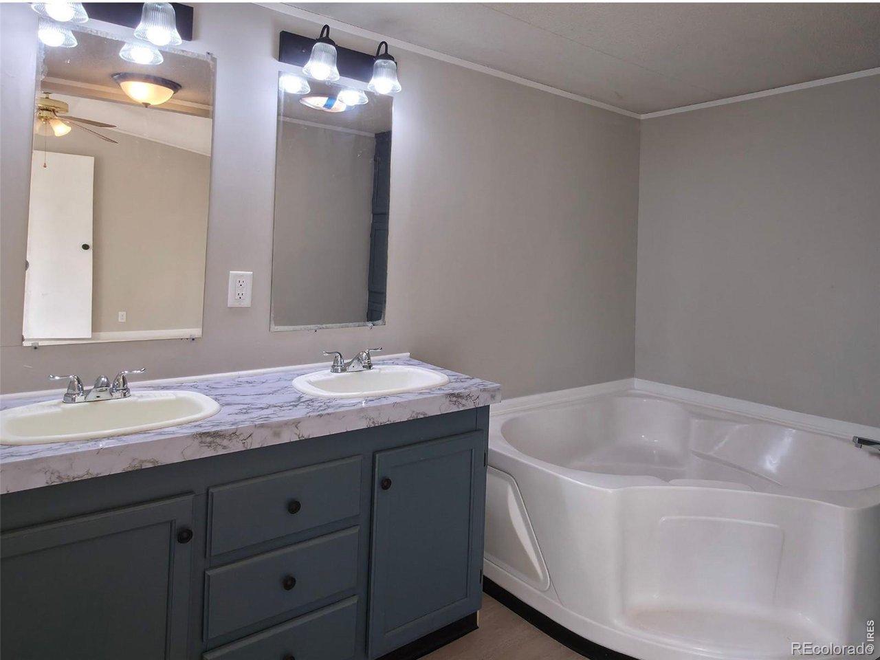 1401 9th Street, Unit 80 Fort Lupton, CO 80621 - Photo 12 of 21 a bathroom with a tub sink and mirror