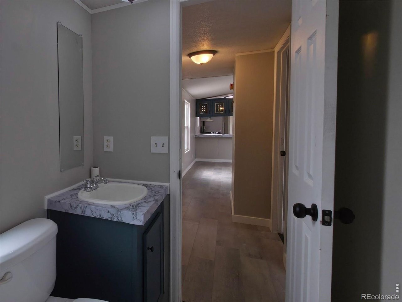 1401 9th Street, Unit 80 Fort Lupton, CO 80621 - Photo 17 of 21 a bathroom with a granite countertop sink and a mirror