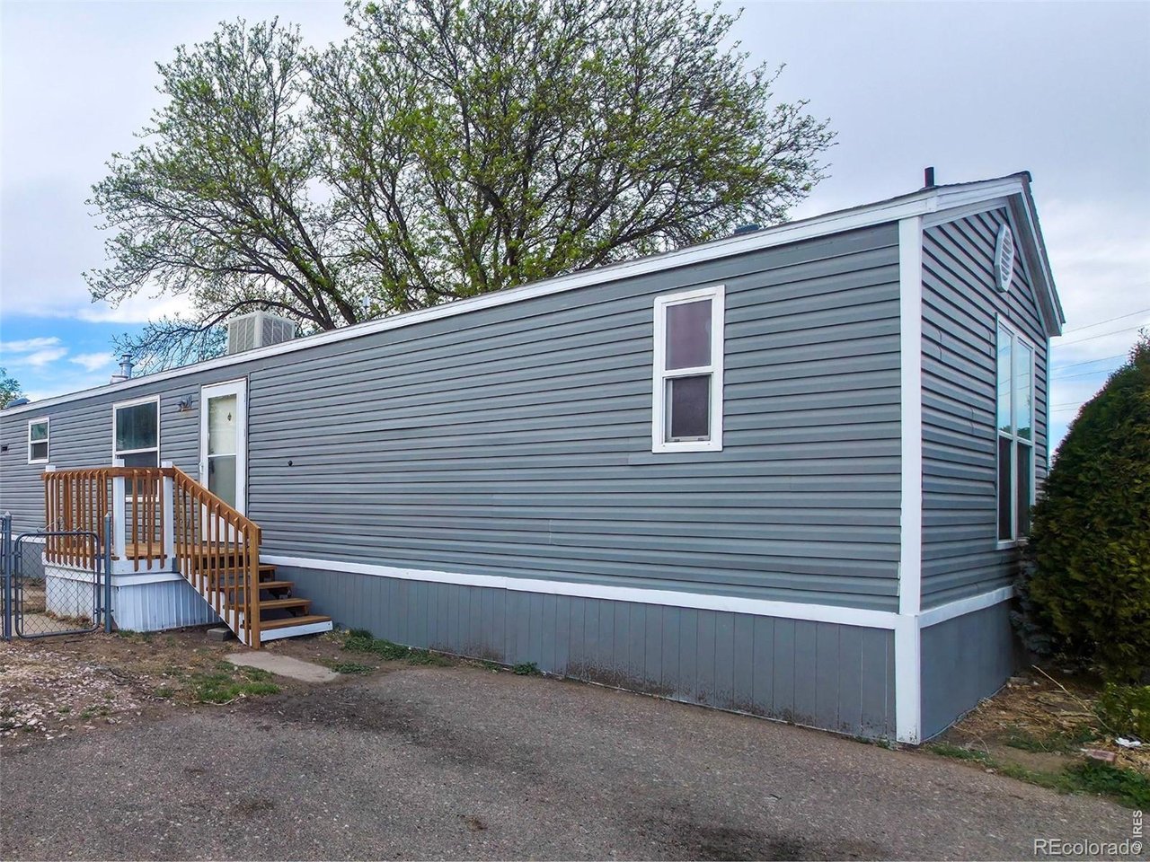 1401 9th Street, Unit 80 Fort Lupton, CO 80621 - Photo 2 of 21 a view of a house with a yard and garage