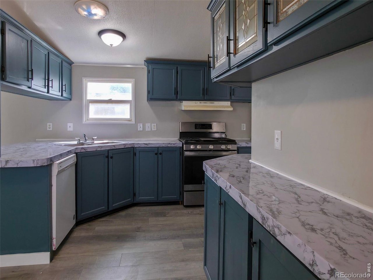 1401 9th Street, Unit 80 Fort Lupton, CO 80621 - Photo 5 of 21 a kitchen with stainless steel appliances granite countertop a sink stove and cabinets