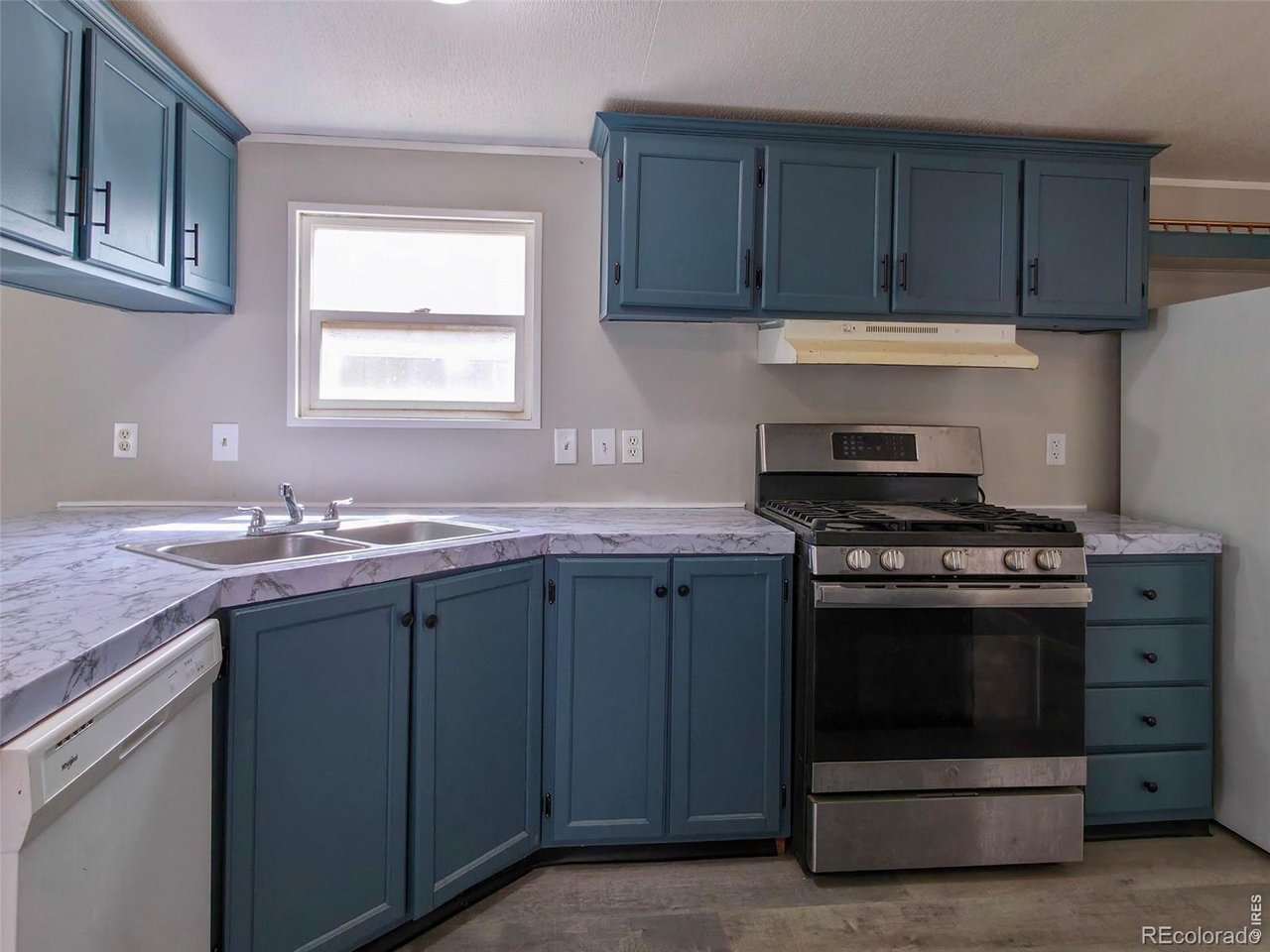1401 9th Street, Unit 80 Fort Lupton, CO 80621 - Photo 6 of 21 a kitchen with wooden cabinets and a stove top oven