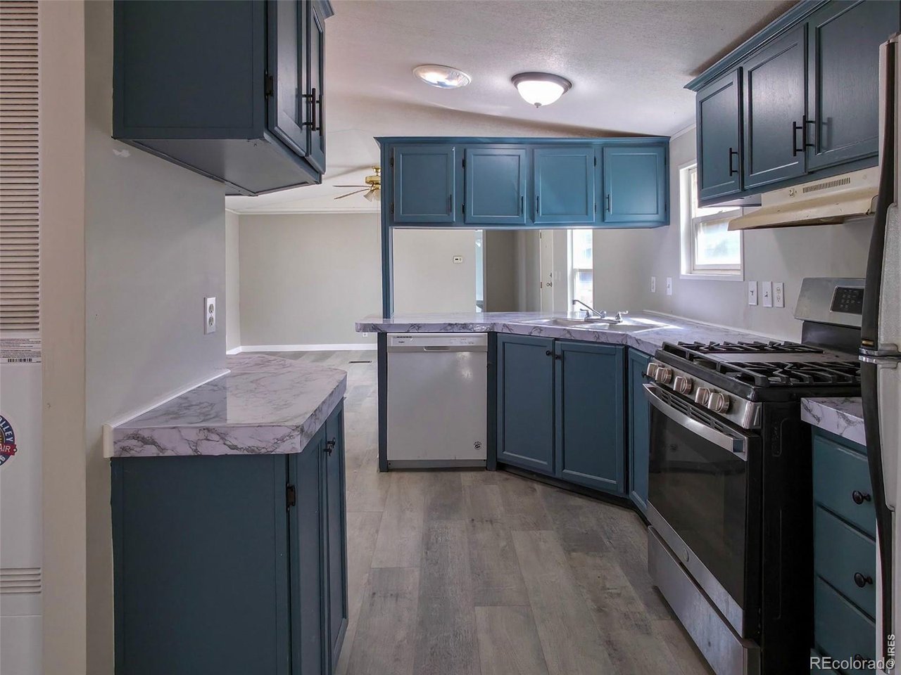 1401 9th Street, Unit 80 Fort Lupton, CO 80621 - Photo 7 of 21 a kitchen with stainless steel appliances granite countertop wooden cabinets sink and stove