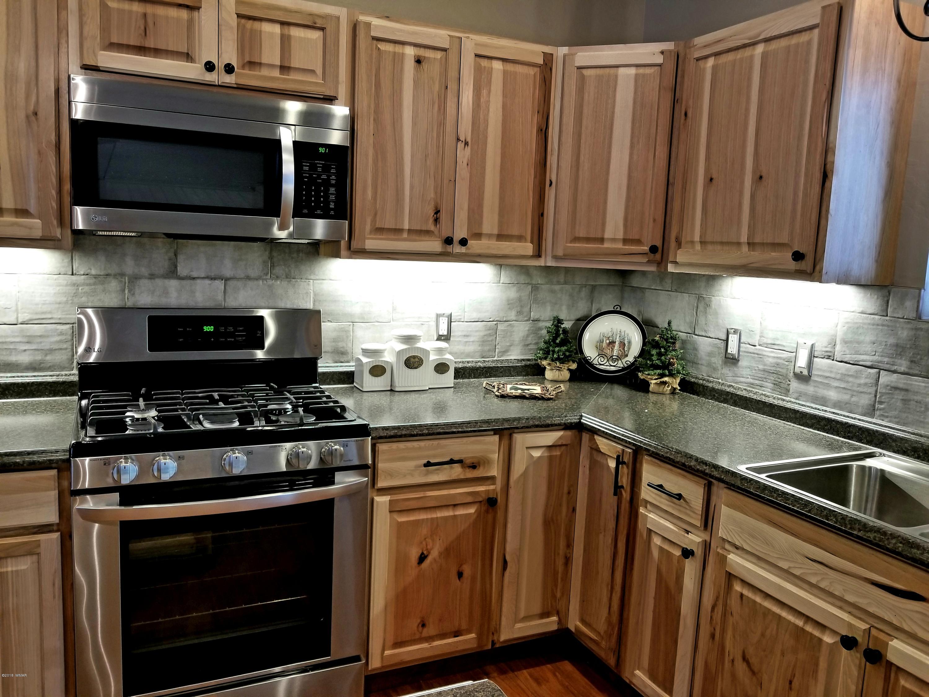 2962 Chestnut Circle, Unit 3 Pinetop, AZ 85935 - Photo 12 of 35 a kitchen with granite countertop a stove top oven microwave and cabinets
