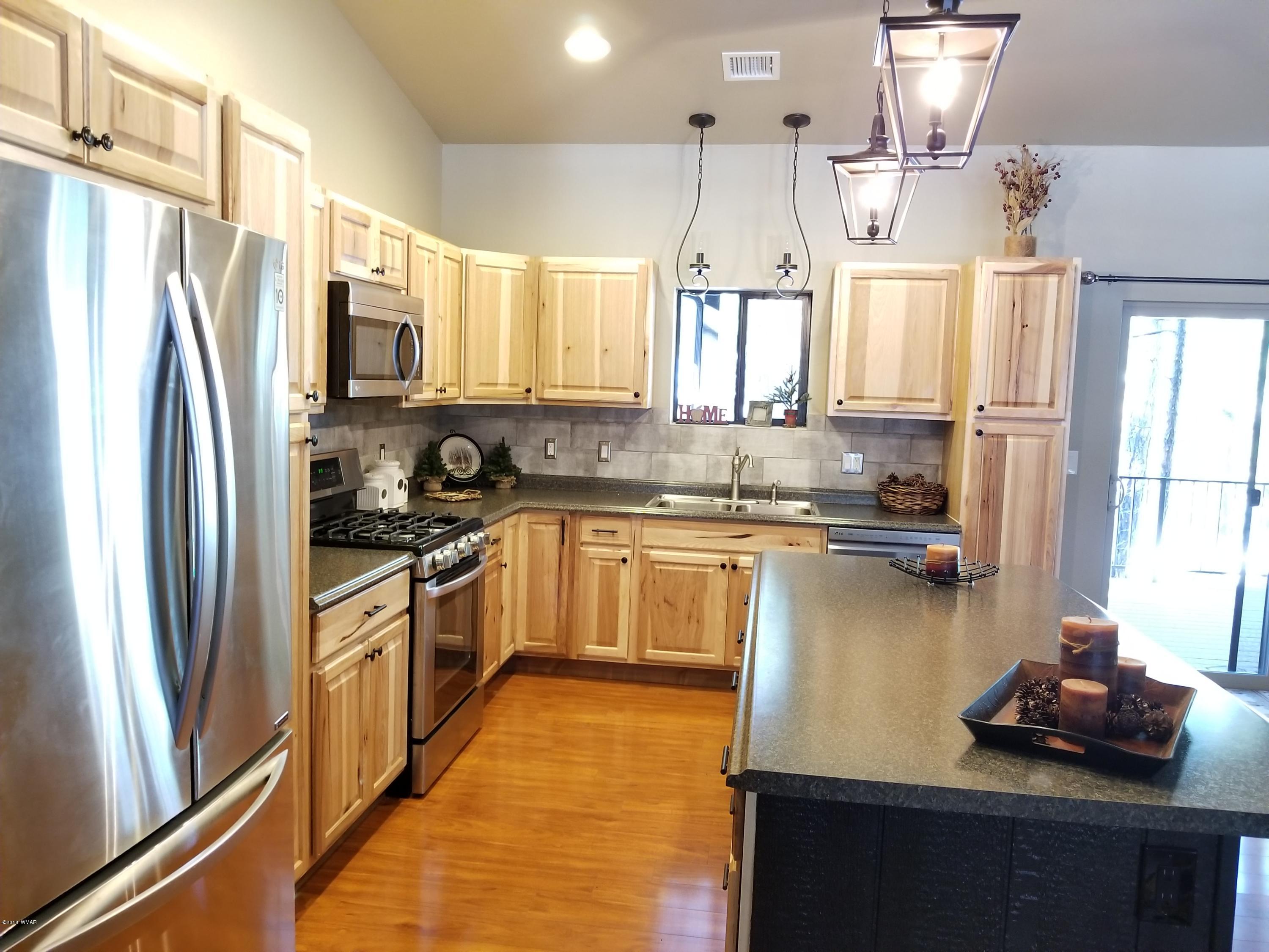 2962 Chestnut Circle, Unit 3 Pinetop, AZ 85935 - Photo 15 of 35 a kitchen with a refrigerator a sink and cabinets