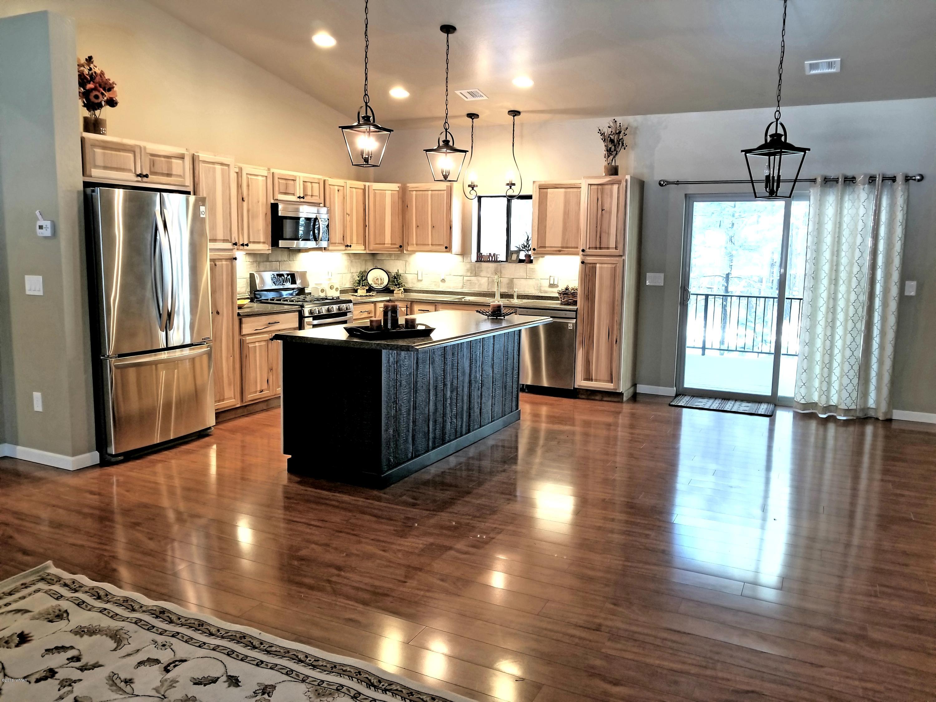 2962 Chestnut Circle, Unit 3 Pinetop, AZ 85935 - Photo 18 of 35 a kitchen with stainless steel appliances wooden floor dining table chairs and wooden floor