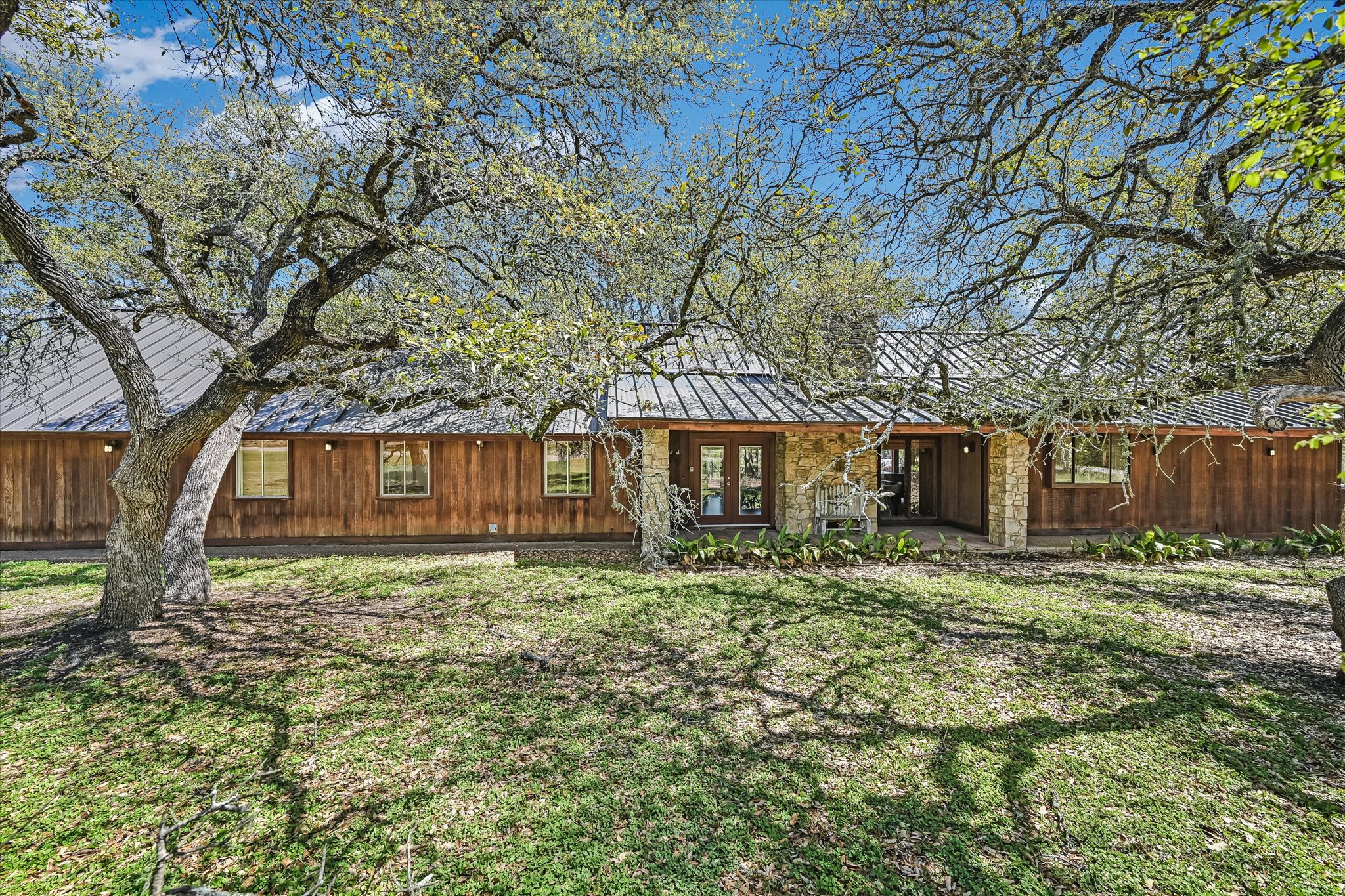 411 Whitetail Ridge Austin, TX 78737 - Photo 1 of 38 Rear view of property featuring a lawn, french doors, and a standing seam roof