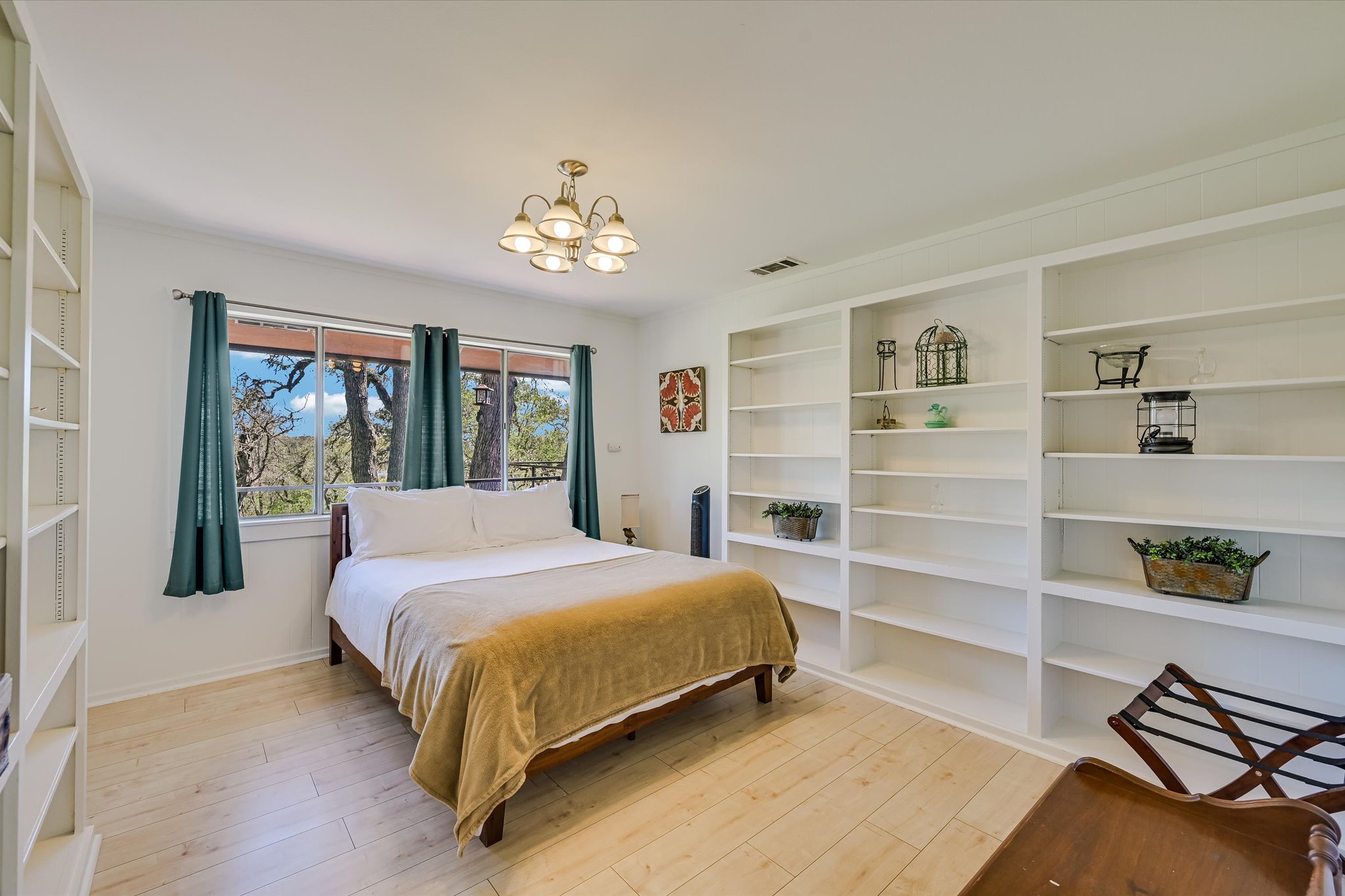 411 Whitetail Ridge Austin, TX 78737 - Photo 16 of 38 Bedroom with light wood-type flooring and a chandelier