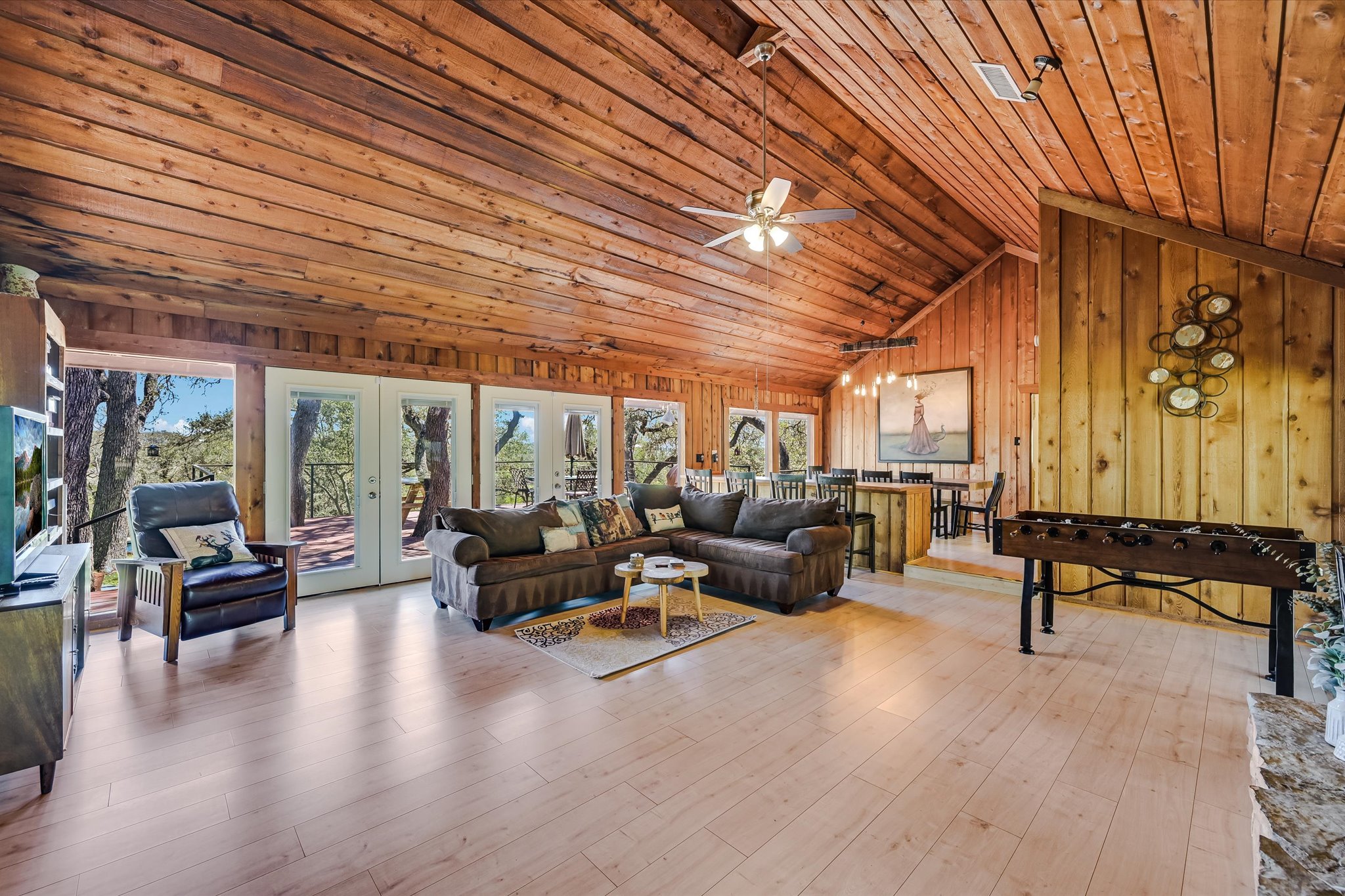411 Whitetail Ridge Austin, TX 78737 - Photo 3 of 38 Living area with french doors, wooden walls, a high wooden ceiling, light wood-style flooring, and a ceiling fan