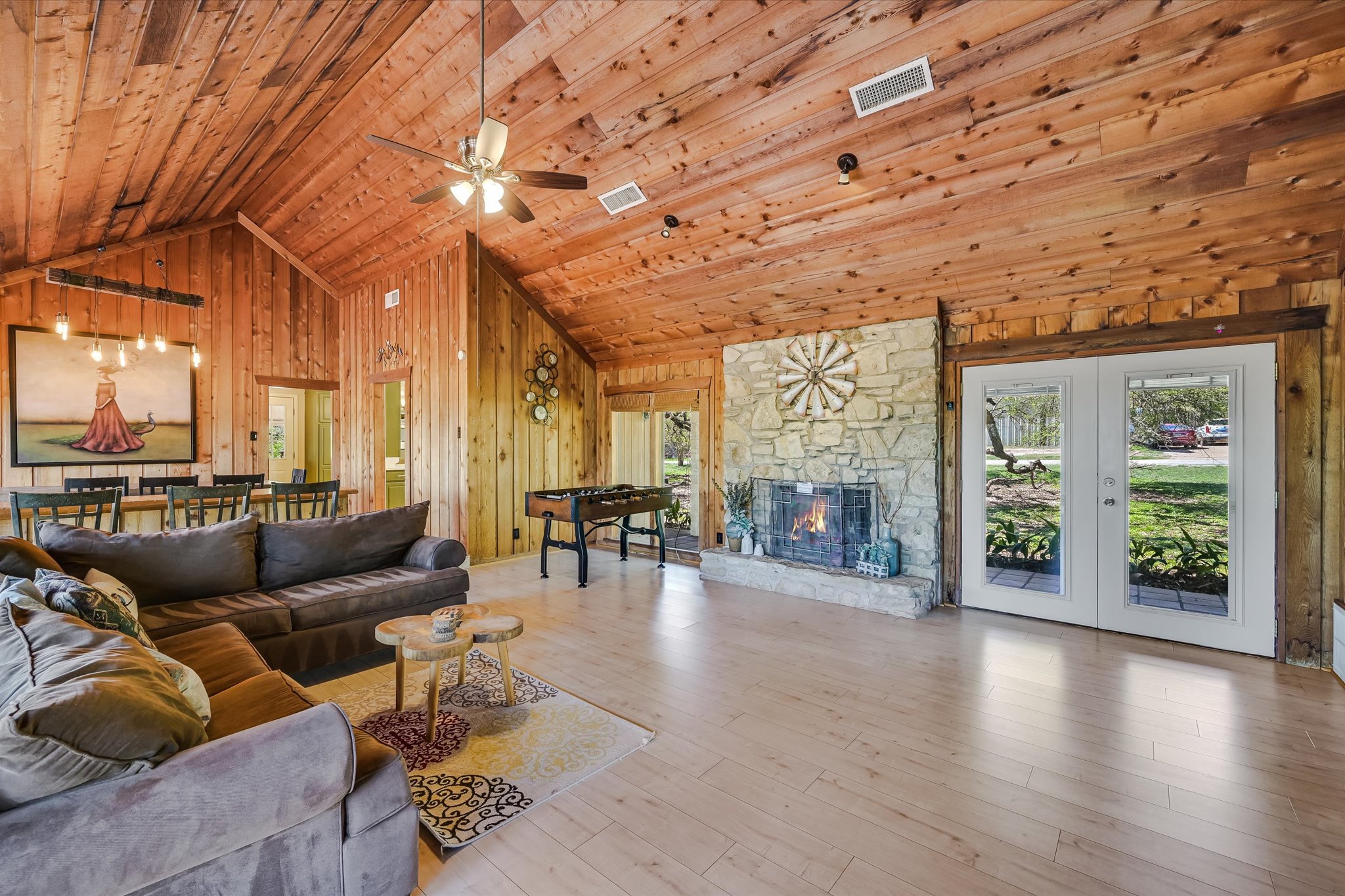 411 Whitetail Ridge Austin, TX 78737 - Photo 5 of 38 Living room with wood walls, a fireplace, light wood-type flooring, a ceiling fan, and a vaulted wooden ceiling
