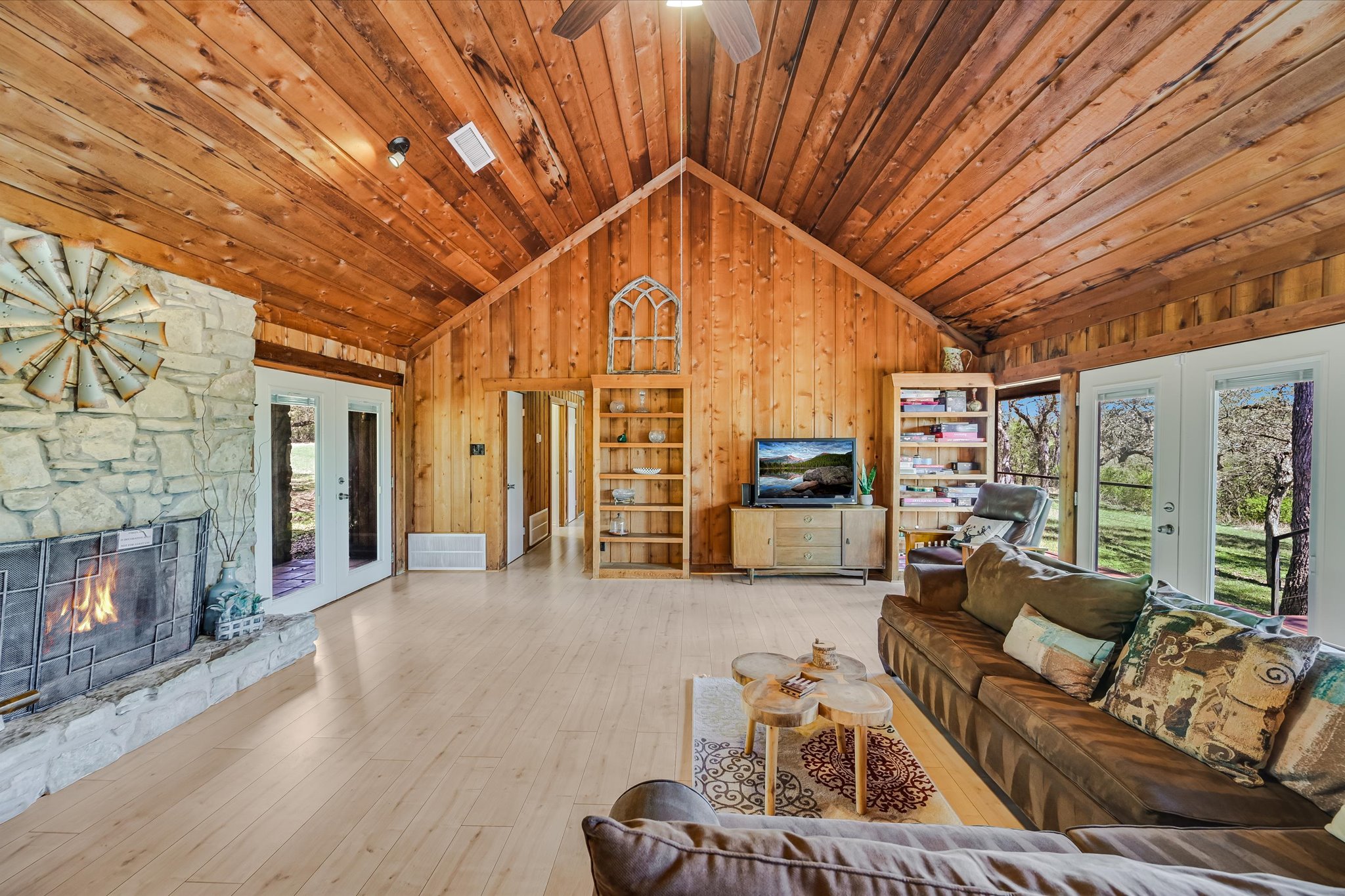 411 Whitetail Ridge Austin, TX 78737 - Photo 6 of 38 Living area featuring french doors, wooden walls, a stone fireplace, a high wooden ceiling, and hardwood / wood-style floors