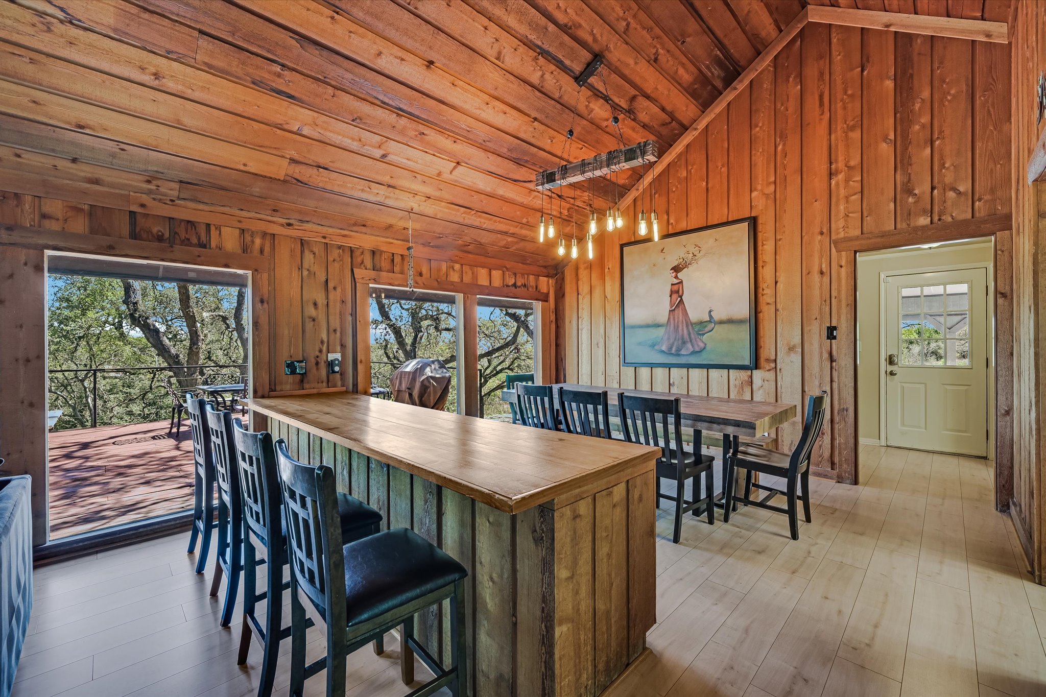 411 Whitetail Ridge Austin, TX 78737 - Photo 8 of 38 Dining area featuring healthy amount of natural light, hardwood / wood-style floors, wood walls, and lofted ceiling