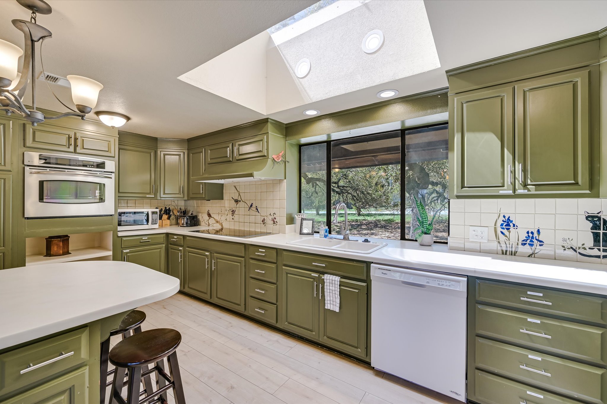 411 Whitetail Ridge Austin, TX 78737 - Photo 10 of 38 Kitchen with green cabinetry, white appliances, light countertops, and recessed lighting