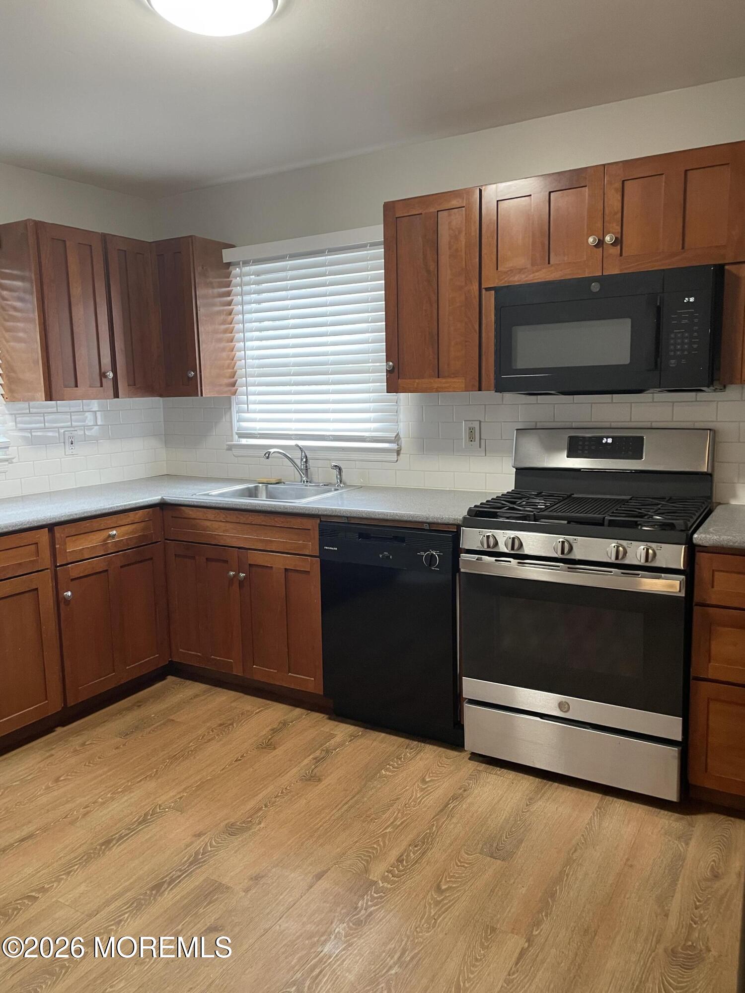 13 Johnson Avenue, Unit 2 Matawan, NJ 07747 - Photo 4 of 10 a kitchen with stainless steel appliances a stove a sink and a microwave