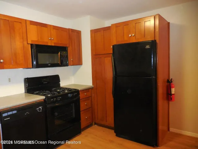 a kitchen with stainless steel appliances granite countertop a refrigerator a stove and a microwave